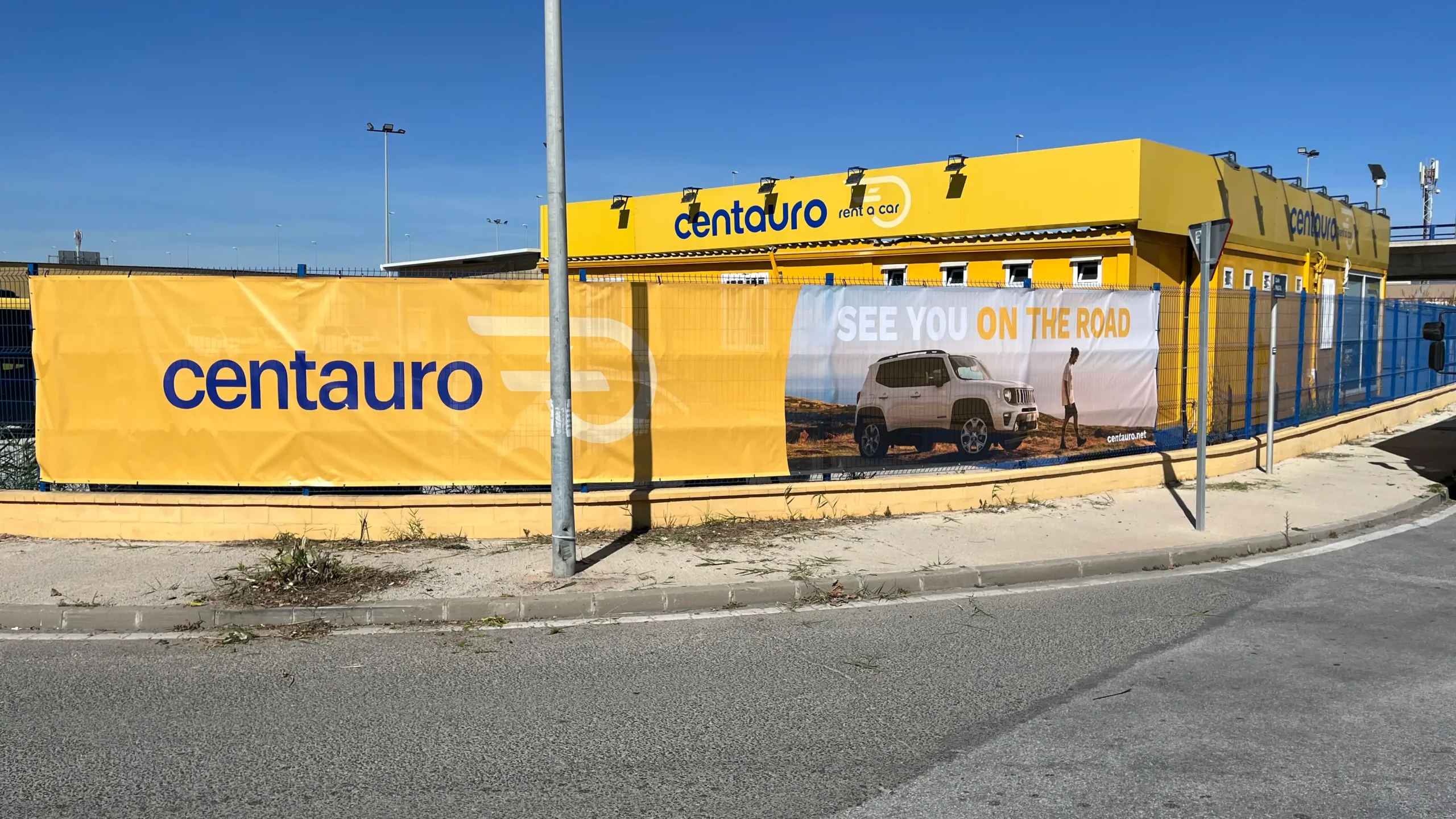 Lona publicitaria instalada en una empresa de alquiler de vehículos